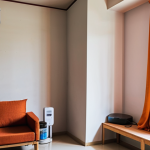 **Prompt 1 (Everyday Impact & Efficiency):** A vibrant, modern Bangladeshi living room bathed in natural light. A sleek smartphone is effortlessly charging with a compact adapter on a minimalist table. In the background, a discreet inverter air conditioner unit is visible, subtly suggesting comfort and energy efficiency. A digital display on a wall or a meter could hint at reduced electricity consumption. The overall scene should convey a sense of convenience, savings, and contemporary living facilitated by power electronics.